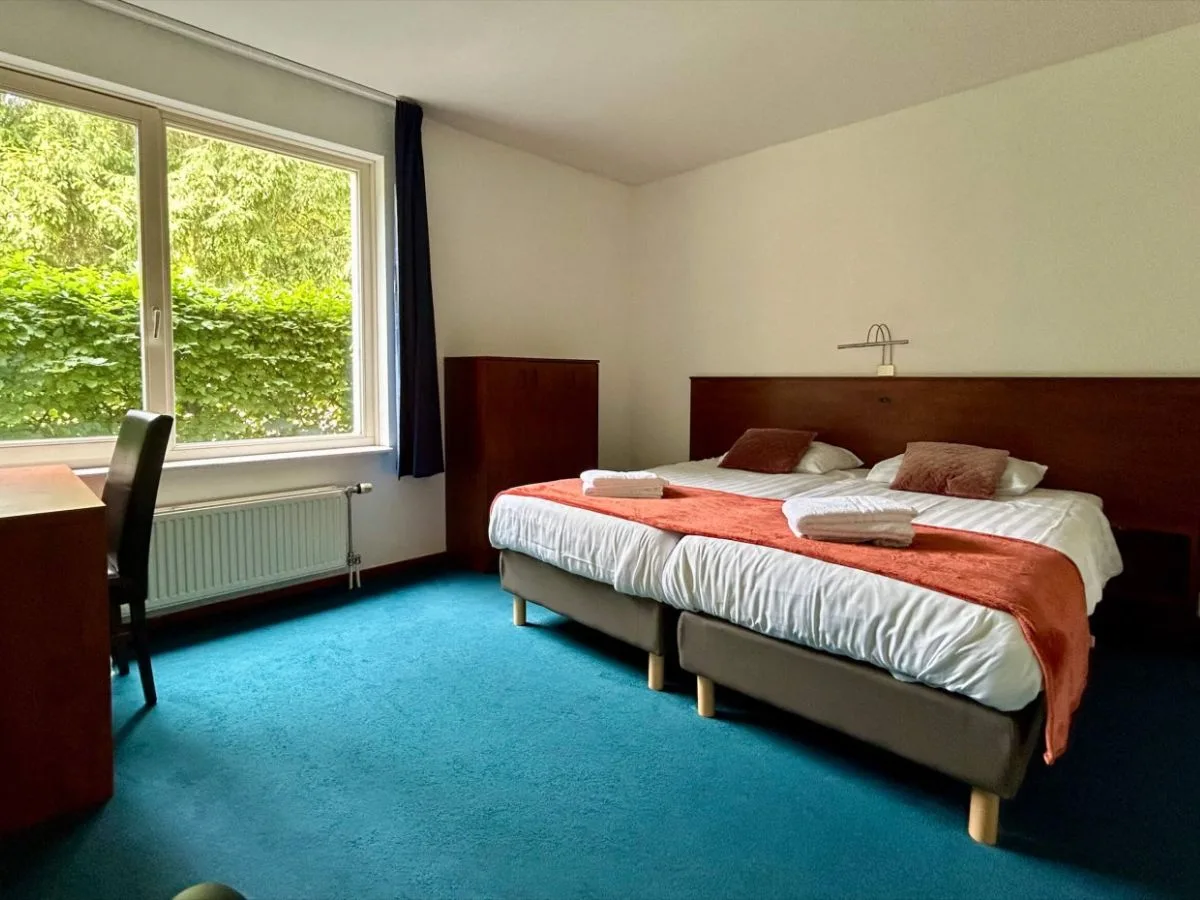 Comfortabele slaapkamers met opgemaakte bedden