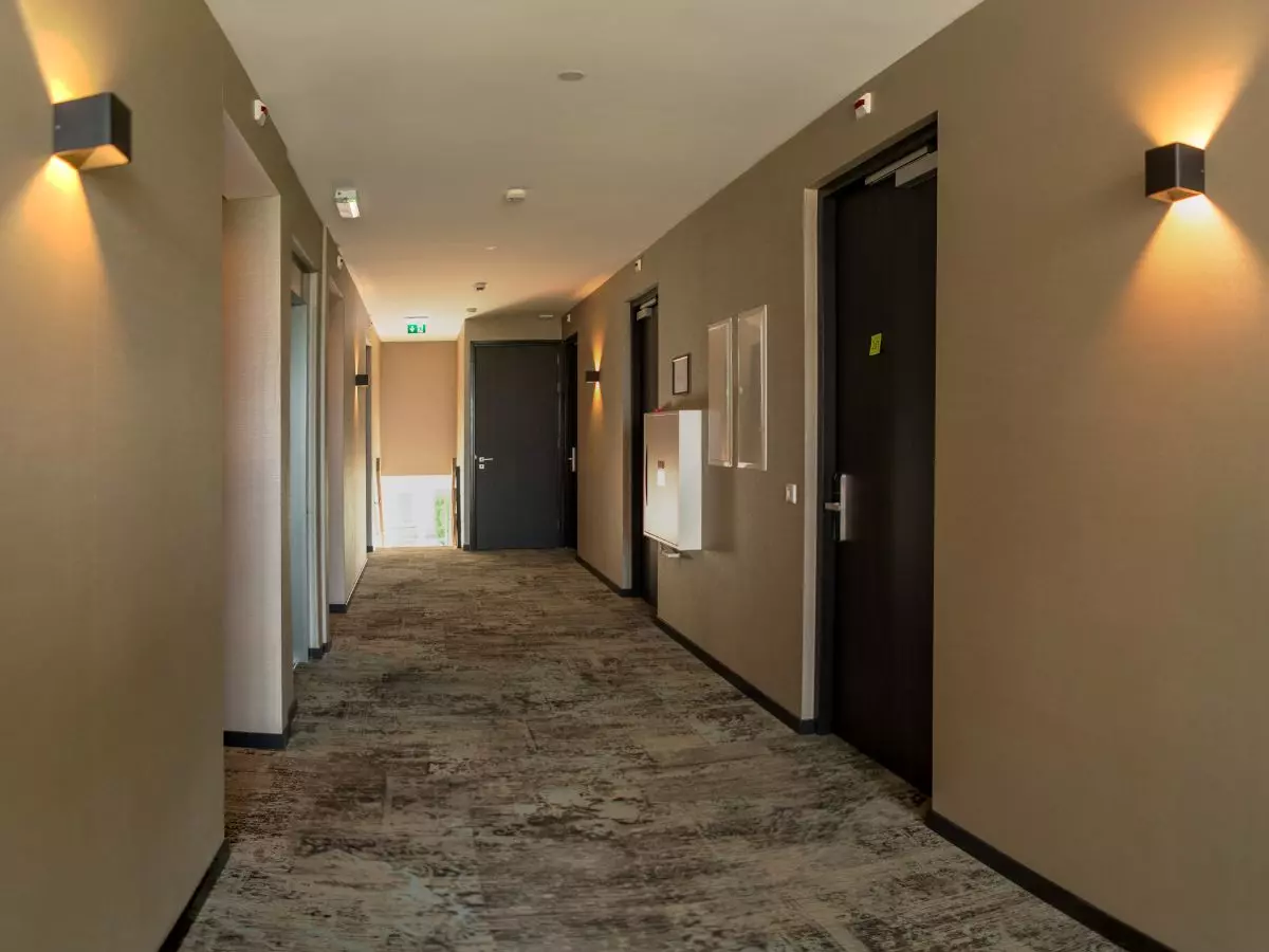 Gang met slaapkamers Op de gangen ervaar je ook de luxe afwerking van het groepshotel